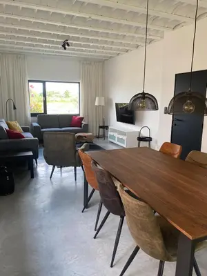 a living room with a wooden table and chairs at Maashuys in Lanaken