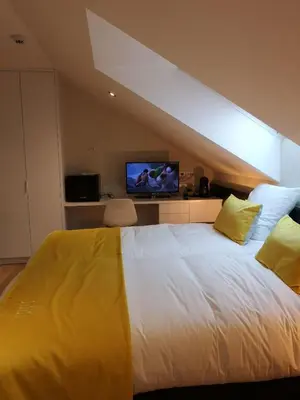 a bedroom with a large white bed with yellow pillows at B&B Atuatuca in Tongeren