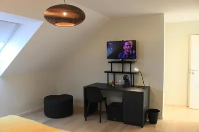 a room with a desk and a tv on the wall at B&B Atuatuca in Tongeren