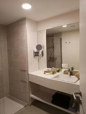 a bathroom with a sink and a shower and a mirror at B&B Atuatuca in Tongeren