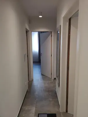 an empty hallway with white walls and a hallway with doors at Vakantiewoning Atuatuca in Tongeren