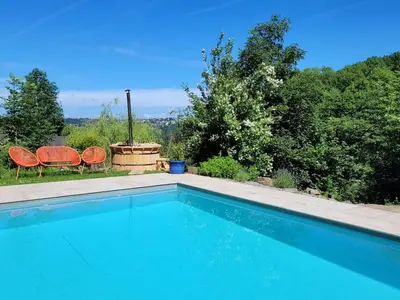 a swimming pool with two orange chairs and trees at Holiday home with sauna and swimming pool in Verviers