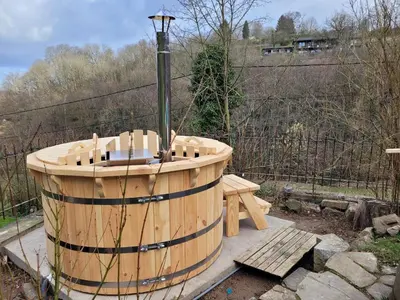 a wooden hot tub with a bench and a street light at Holiday home with sauna and swimming pool in Verviers