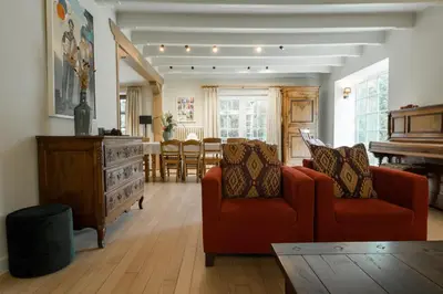 a living room with two red chairs and a piano at Vakantiewoning De zandberg in Pelt