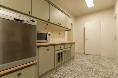 a kitchen with white cabinets and a microwave oven at Vakantiewoning De zandberg in Pelt