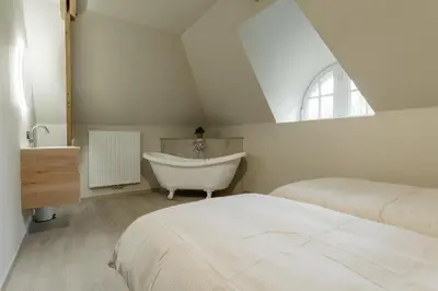 a bedroom with a bed and a bath tub at Vakantiewoning De zandberg in Pelt