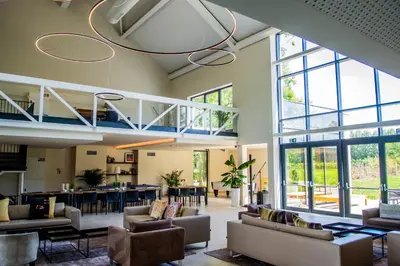 a large room with couches and tables and windows at Hof van Stayen in Sint-Truiden