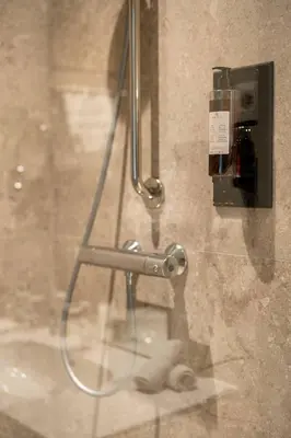 a shower stall with a faucet on a wall at Hof van Stayen in Sint-Truiden