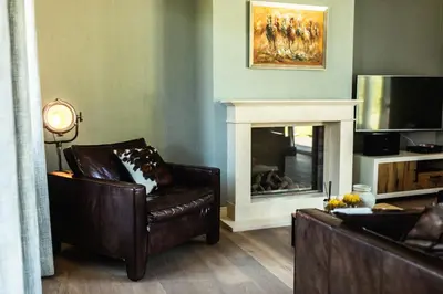 a living room with a couch and a fireplace at Kolisheide in Peer
