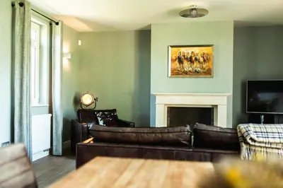 a living room with a leather couch and a fireplace at Kolisheide in Peer