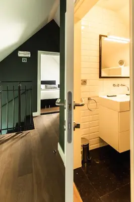 a bathroom with a sink and a bathroom with a bed at Kolisheide in Peer