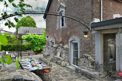 a patio with a table in front of a brick building at Landhaus Lontzen in Lontzen