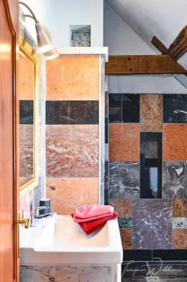 a bathroom with a white sink and a tile wall at Landhaus Lontzen in Lontzen