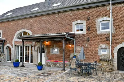 a brick building with a table and chairs in front of it at Landhaus Lontzen in Lontzen