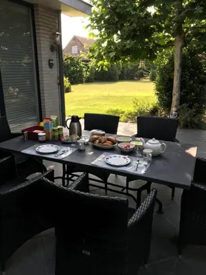 a table with a plate of food on a patio at Hazegewoud in Arendonk
