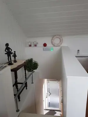 a staircase in a kitchen with a table and a refrigerator at De achtertuin in Maasmechelen