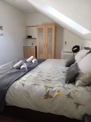 a bedroom with a large bed with towels on it at De achtertuin in Maasmechelen