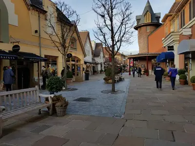 a street in a town with people walking down the street at De achtertuin in Maasmechelen