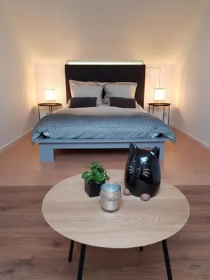 a bedroom with a bed and a table with a table sidx sidx sidx at De achtertuin in Maasmechelen