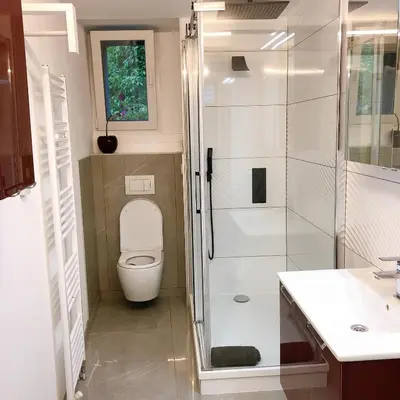 a bathroom with a toilet and a glass shower at VIP 67 in Eupen