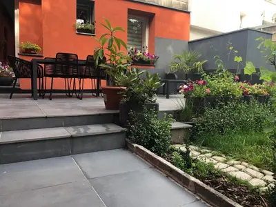 a patio with a table and chairs and flowers at VIP 67 in Eupen