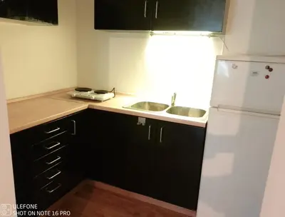 a kitchen with a white refrigerator and a sink at Logement Régence in Liège