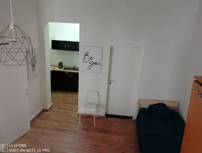 a living room with two white doors and a chair at Logement Régence in Liège