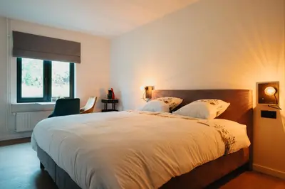 a bedroom with a large white bed with two pillows at 't Wilgenhuys in Lommel