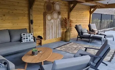a patio with a couch and chairs and a table at 't Wilgenhuys in Lommel