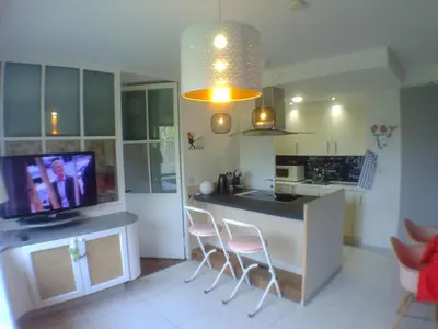 a kitchen with a island with chairs and a tv at Liège centre 6 rue montagne sainte Walburge, 4000 Liège, pour 2 pers à 3 minutes de la gare st Lambert in Liège
