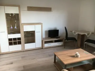a living room with a tv and a table at Chalet M in Eupen