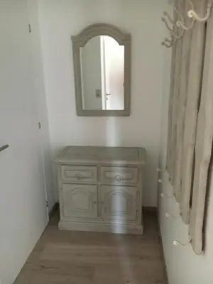 a bathroom with a wooden dresser and a mirror at Chalet M in Eupen
