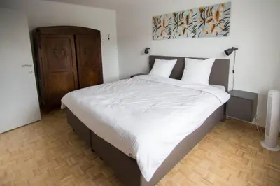 a bedroom with a large bed with white sheets at Villa Domus XIX in Tongeren