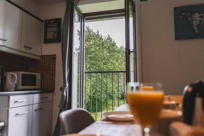 a kitchen with a table and a door to a balcony at Vakantiewoning & Fietslogies VELO, rustig vlakbij Maastricht in Bilzen