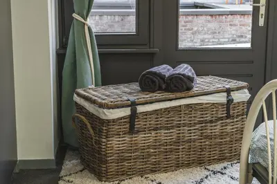 a wicker basket with towels on top of it at Vakantiewoning & Fietslogies VELO, rustig vlakbij Maastricht in Bilzen