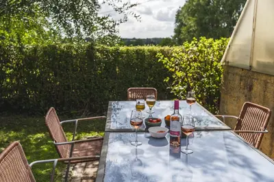 a table with wine bottles and glasses on it at Vakantiewoning & Fietslogies VELO, rustig vlakbij Maastricht in Bilzen