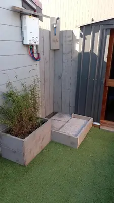 a backyard patio with two beds on the grass at Maas Chalet Aldeneik in Maaseik