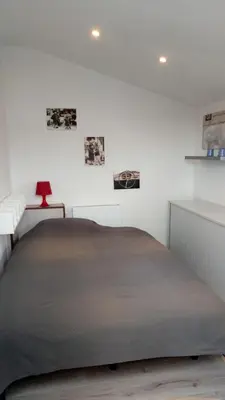 a bedroom with a large bed in a white room at Maas Chalet Aldeneik in Maaseik