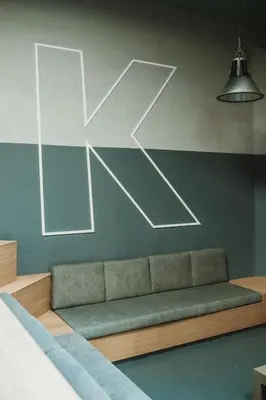 a couch in a room with a sign on the wall at Kindadom - Maison pour vacances insolites et inoubliables en Belgique in Montzen