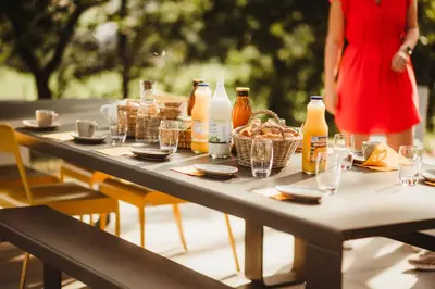 a table with food and drinks and a woman in a red dress at Kindadom - Maison pour vacances insolites et inoubliables en Belgique in Montzen