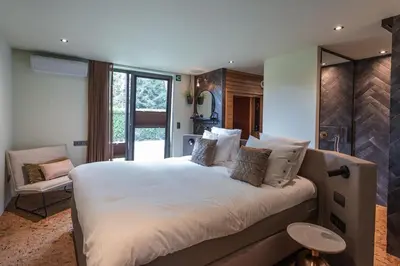 a bedroom with a large white bed and a chair at Bed & Breakfast Nummer5 in Heusden - Zolder