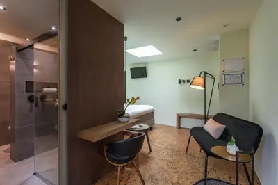 a room with a shower and a bed and a desk and chairs at Bed & Breakfast Nummer5 in Heusden - Zolder