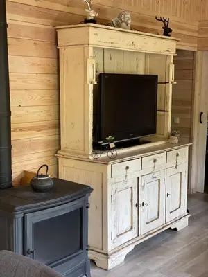 a wooden entertainment center with a tv on top of it at Chalet Sint-Hubertus Deluxe in Zutendaal