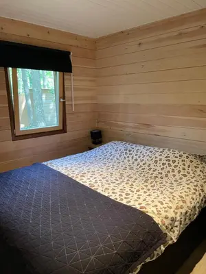 a bedroom with a bed in a room with a window at Chalet Sint-Hubertus Deluxe in Zutendaal