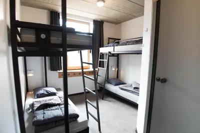 a room with two bunk beds and a doorway at HI Liège Hostel in Liège