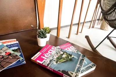 two magazines sitting on top of a table at HI Liège Hostel in Liège