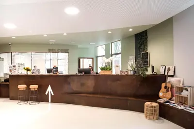 a restaurant with a counter with a guitar in a room at HI Liège Hostel in Liège