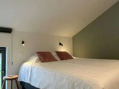 a bedroom with a large white bed with red pillows at Vakantiewoning Laurijn in Bilzen