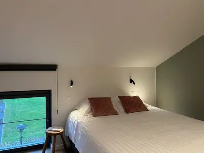 a bedroom with a bed and a large window at Vakantiewoning Laurijn in Bilzen