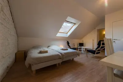 a attic bedroom with a bed and a skylight at B&B 't Maanhof in Gingelom